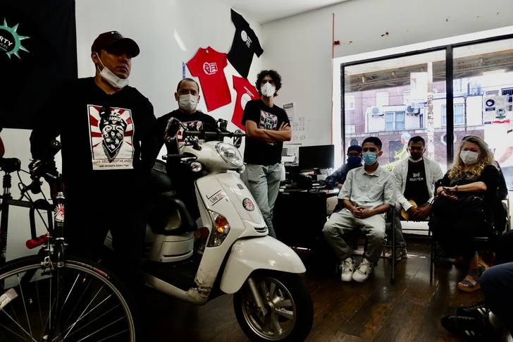 A photo of e-bike workers and officials gathered in the Workers Justice Project offices. Los Deliveristas are urging NYCHA not to ban e-bikes.